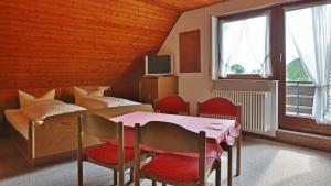 策尔阿姆哈尔梅尔斯巴赫格努讷霍夫酒店的卧室配有一张床和一张桌子及椅子