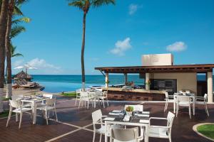 新巴利亚塔Krystal Grand Nuevo Vallarta的海滩上的餐厅,配有桌椅