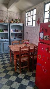 布宜诺斯艾利斯Casa Reina Palermo Queens的厨房配有木桌和红色冰箱。