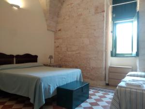 法萨诺Splendida villa a Selva di Fasano的一间卧室设有一张床和砖墙