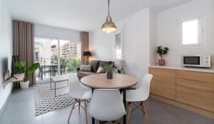 福恩吉罗拉Sur Suites La Dorada的厨房以及带桌椅的起居室。