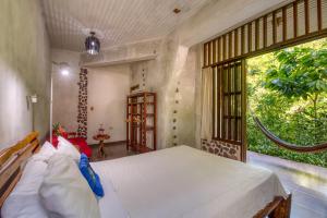 拉塞瓦欧米茄旅游生态山林小屋的一间卧室设有一张大床和一个大窗户