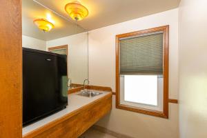 马里波萨河石旅馆的一间带大屏幕平面电视和水槽的浴室