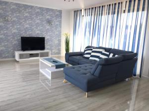 达洛科Apartamenty Przy Latarni Kropla Bałtyku的客厅配有蓝色的沙发和电视