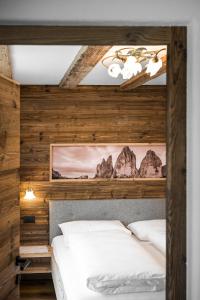 圣洛伦佐-迪塞巴托Chalet Dolomit的卧室设有2张白色的床和木墙