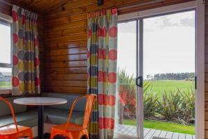 Little WanganuiLittle Wanganui Hotel的客房设有桌椅和窗户。