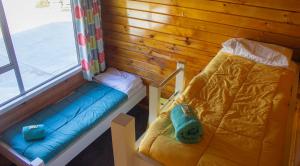 Little WanganuiLittle Wanganui Hotel的一间设有床的房间,一个靠窗的长凳