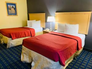 盖恩斯维尔盖恩斯维尔优值汽车旅馆的酒店客房,配有两张带红色床单的床