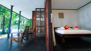 Rabia瓦伊沃拉贾安帕潜水假日公园的卧室配有一张床和一张桌子及椅子