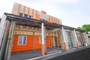 三宝垄Super OYO 1250 Unta Residence的橙色的建筑,前方是橙色的,设有窗户