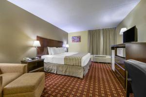 Triadelphia特瑞阿德尔福亚伊克诺套房旅店的酒店客房设有一张大床和一张沙发。