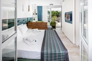 利尼亚诺萨比亚多罗皇宫酒店的一间卧室配有一张床铺,床上有婴儿毛毯