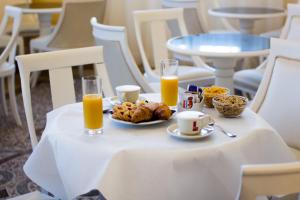 利沃诺环球酒店的一张桌子,上面放着一盘食物和两杯橙汁