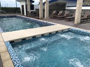 达沃市Blue Lotus Hotel的庭院内的一个蓝色瓷砖游泳池