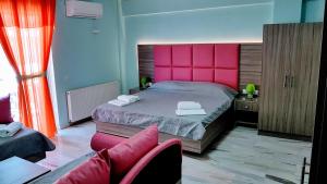 奥林匹亚基·阿克蒂白玫瑰海滩酒店的一间卧室配有一张带粉红色床头板的大床