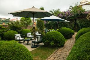 菲亚纳兰楚阿Tsara Guest House的庭院配有桌椅和遮阳伞。