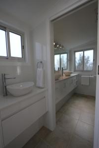 霍巴特穆那中心公寓酒店的白色的浴室设有两个盥洗盆和大镜子