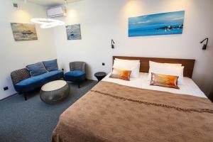 符拉迪沃斯托克SV Hotel的一间卧室配有一张大床和一张蓝色椅子