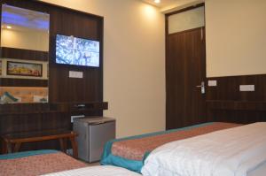 新德里恒河小屋旅馆的酒店客房设有两张床和一台平面电视。