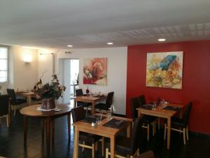 菲雅克Le Relais de la Tour的餐厅设有木桌、椅子和红色的墙壁