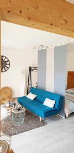 热拉梅Appartement 50m du Lac的一张蓝色的沙发,位于带床的房间