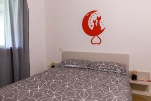 PolcenigoAppartamento Sonelia的卧室配有一张床铺,墙上挂着猫标签