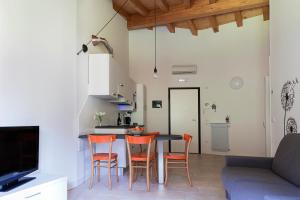 PolcenigoAppartamento Sonelia的厨房以及带桌椅的起居室。