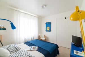 布科·莱斯白老城Le Studio Bleu de la gare的一间卧室配有床和黄色灯