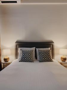 根特La Lys Rooms & Suites的卧室配有带枕头和两盏灯的白色床。