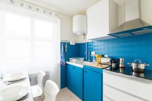 布科·莱斯白老城Le Studio Bleu de la gare的蓝色的厨房,配有白色橱柜和蓝色瓷砖