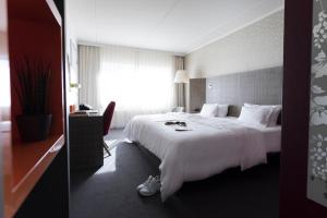艾森纳赫pentahotel Eisenach的酒店客房设有一张白色大床和一个窗户。