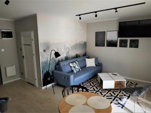 巴尔托希采Apartament Limanowskiego 20/6的客厅配有蓝色的沙发和桌子