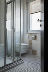 里德因克瑞斯里德H +酒店的带淋浴、浴缸和卫生间的浴室