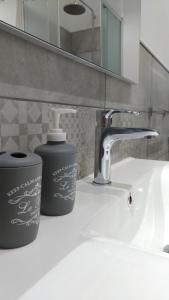 特拉帕尼Sunrise Beach Apartment Trapani的浴室水槽设有水龙头和肥皂容器