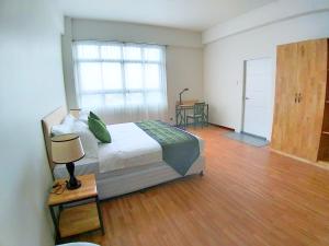 仰光Myanandar Residence & Hotel的一间卧室配有一张床,铺有木地板