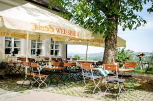 罗丁Wallfahrts-Gaststätte Heilbrünnl的树下设有桌椅的餐厅