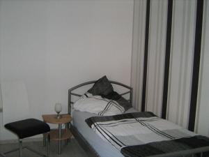 黑德Ferienzimmer Alte Kämpe的一间卧室配有一张床、一把椅子和一张桌子