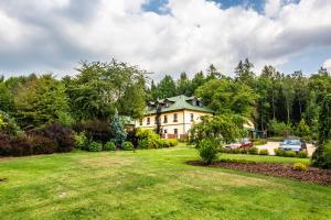 利帕河畔卡梅尼采约翰卡度假酒店的一座大房子,位于一个绿色草坪的庭院内