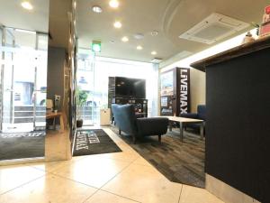 东京HOTEL LiVEMAX BUDGET Shinbashi的大堂设有1间带椅子和桌子的等候室