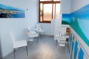 那不勒斯B&B Le isole的客房设有2张桌子和椅子以及窗户。