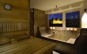 马里博尔Hotel Maribor & Garden Rooms的带浴缸和窗户及时钟的房间