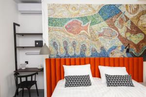 符拉迪沃斯托克SV Hotel的一间卧室配有橙色床头板和色彩缤纷的墙壁