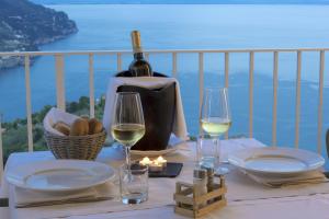 拉维罗皮耶迪蒙特别墅酒店的一张桌子,上面放着一瓶葡萄酒和两杯酒