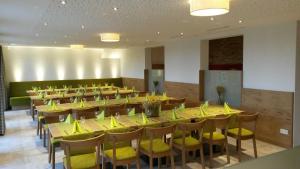 OedheimFerienhof Laurentius的大型用餐室配有黄色的桌椅