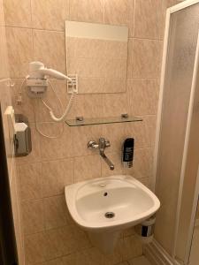 VažecUbytovanie Violet的一间带水槽的浴室和墙上的一部电话