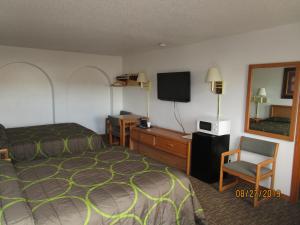 MandanNorth Country Inn & Suites的酒店客房,配有床和电视