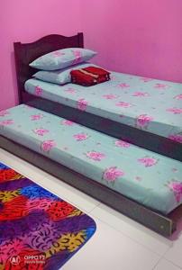 甲抛峇底Nurul Homestay的配有粉红色墙壁的客房内的两张床