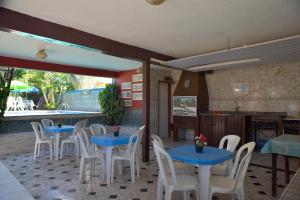 塞古罗港Pousada Recanto de Minas的一间设有蓝色桌子和白色椅子的餐厅
