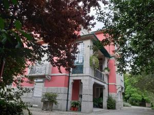吉马良斯埃斯皮霍萨住宿加早餐旅馆的粉红色和白色的房子,设有阳台