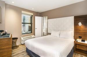 纽约加里凡时代广场的卧室设有一张白色大床和一扇窗户。